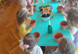 Dzieci sadzące rośliny w doniczkach