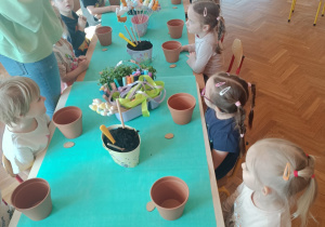 Dzieci sadzące rośliny w doniczkach