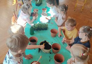 Dzieci sadzące rośliny w doniczkach