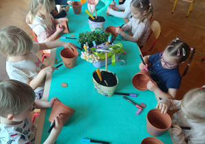 Dzieci sadzące rośliny w doniczkach