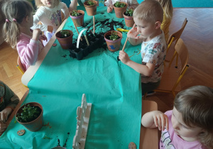 Dzieci sadzące rośliny w doniczkach