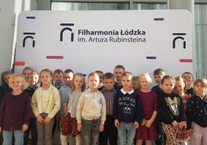 Przedszkolaki pozujące do zdjęcia na ściance w Filharmonii Łódzkiej