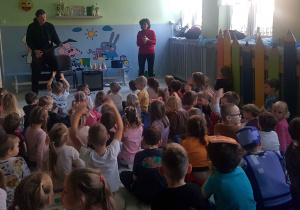 Grupa dzieci z zaciekawieniem słucha koncertu muzycznego